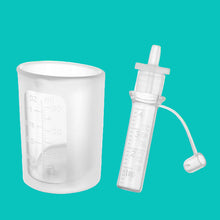 Load image into Gallery viewer, Clear measuring cup and syringe with measurement markings on a white background
